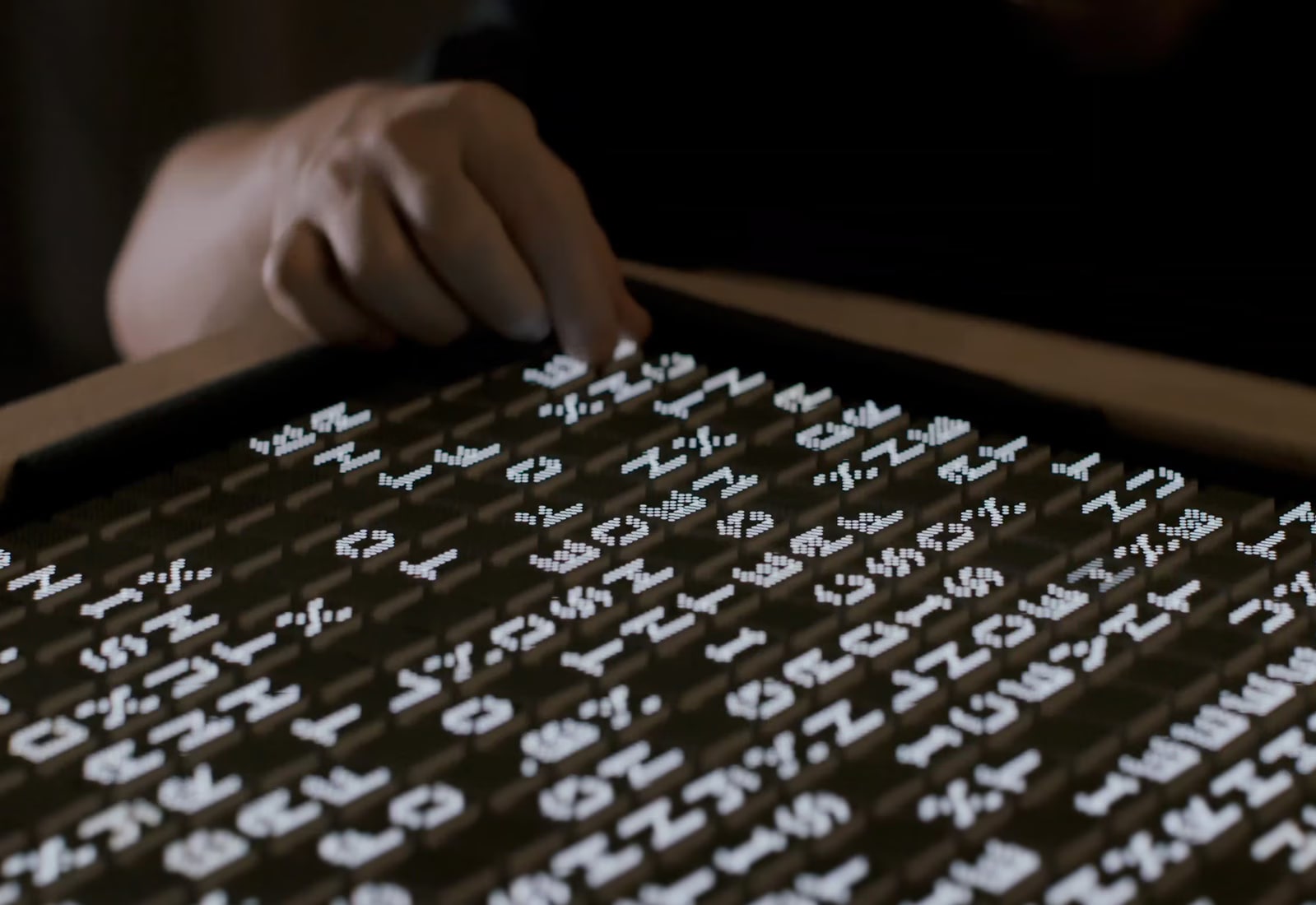 Matt Clark is touching on screen that has electronic alphabets on it