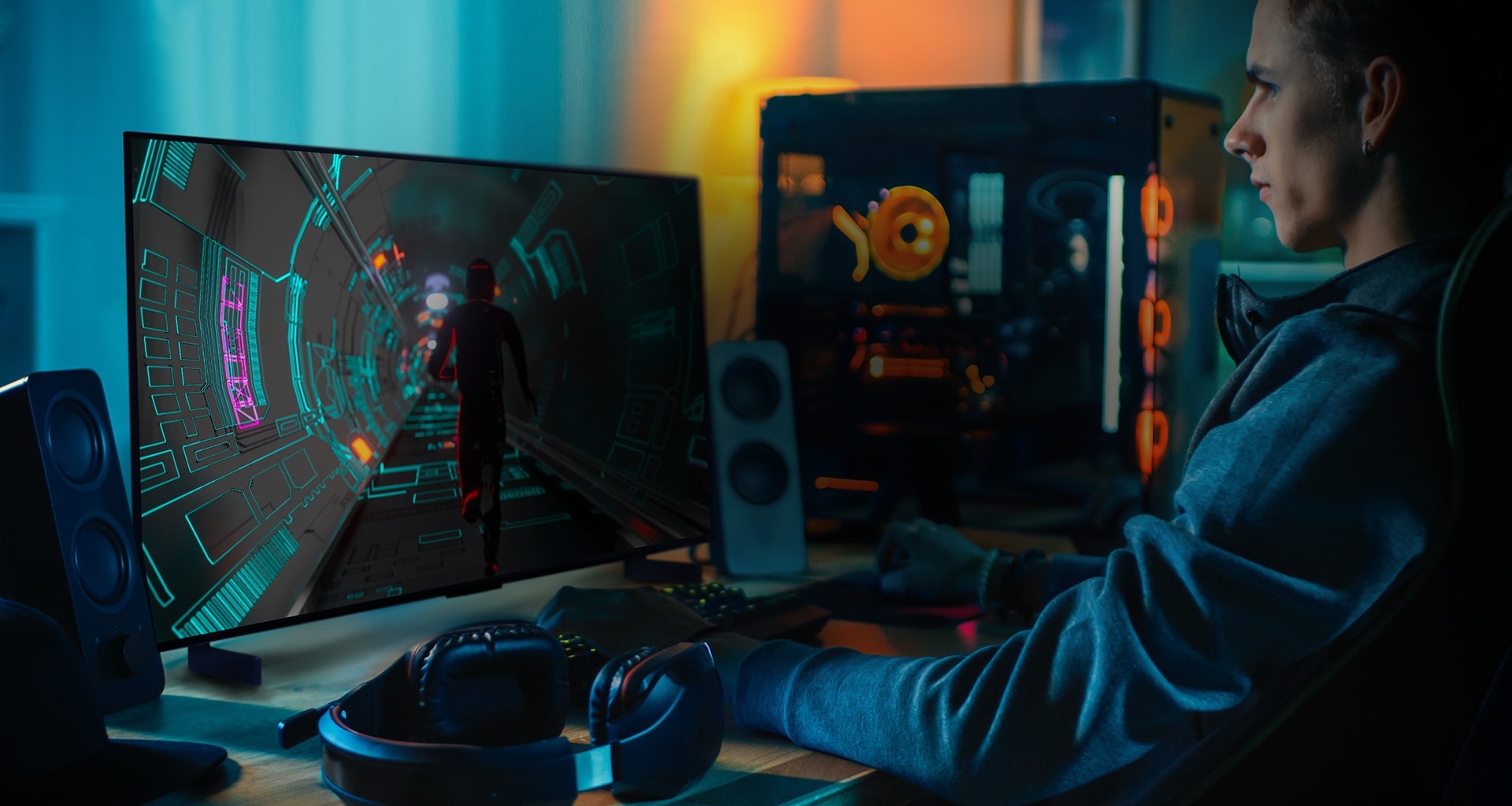 Iemand speelt een sci-fi spel aan zijn persoonlijk bureau op een kleine LG OLED televisie