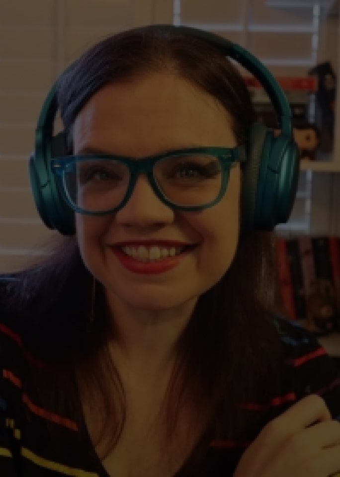 Casey Fiesler está sorrindo brilhantemente enquanto usa um fone de ouvido.