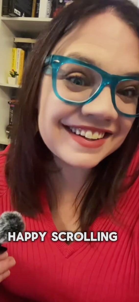 Mulher de óculos azuis e suéter vermelho, sorrindo com o texto 'HAPPY SCROLLING' na parte inferior.