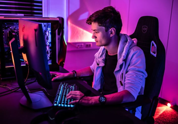 Uma caverna masculina com um setup de jogos imersivo, incluindo um monitor de jogos de alta qualidade, criando uma experiência visual intensa em um espaço pessoal e acolhedor.