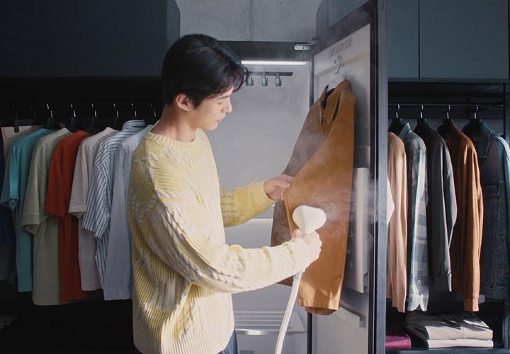 Um homem usa o LG Styler para tratar e higienizar roupas a vapor, demonstrando a avançada tecnologia que deixa as roupas desamassadas.