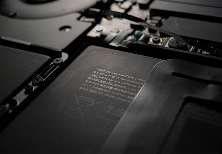 Visão aproximada de uma bateria recarregável de íons de lítio dentro de um notebook, com destaque para o texto informativo e os ícones de descarte.