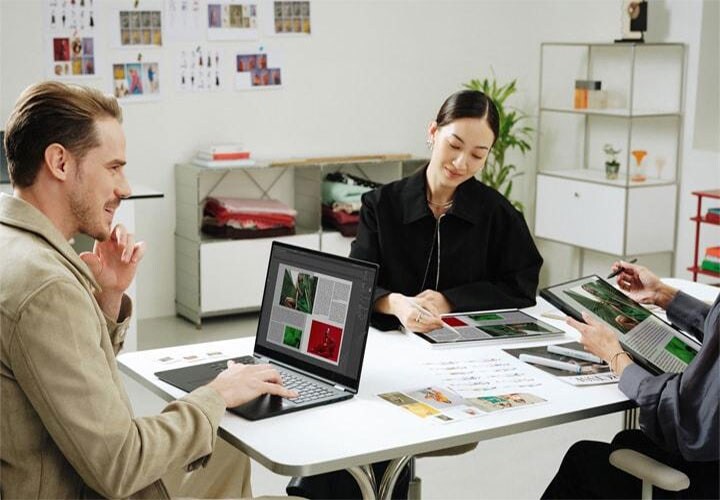 Três profissionais em uma reunião, cada um trabalhando em um notebook LG gram.