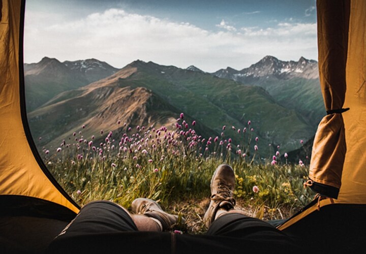 Vista de dentro de uma barraca capturando uma paisagem cênica, onde o uso de gadgets de camping pode melhorar a experiência ao ar livre