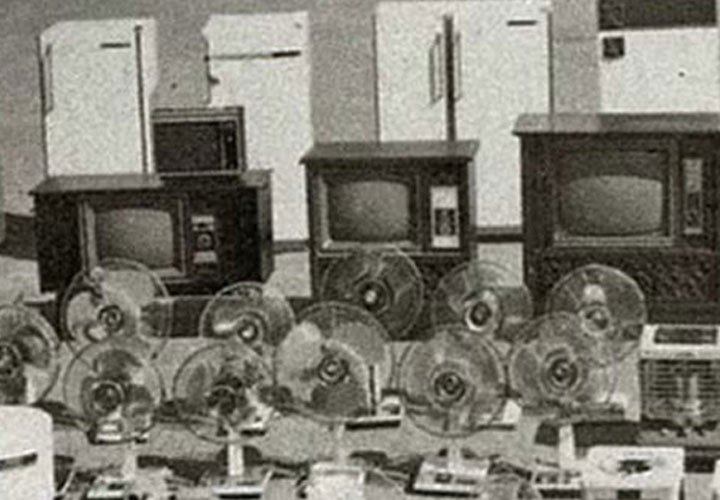 Fileiras de eletrônicos antigos, incluindo geladeiras, TVs e muito mais, são exibidas em preto e branco.