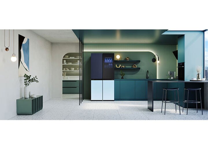 Cozinha moderna com armários azul-petróleo elegantes, uma geladeira LG MoodUP com porta gradiente, prateleiras abertas, decoração minimalista e uma grande ilha com bancos de bar. A luz natural inunda o espaço através de uma grande janela.
