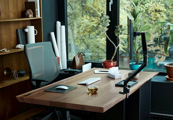 Configuração de escritório doméstico com ferramentas essenciais, como móveis ergonômicos e acessórios de trabalho, complementados por monitores e displays de alta qualidade.