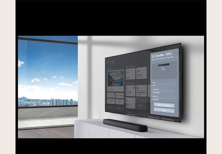 Uma TV LG montada na parede exibe o menu de configurações de uma soundbar LG, com a própria soundbar colocada em um rack branco minimalista abaixo da TV. A interface da TV LG destaca as configurações de som e conexões do aparelho, enfatizando o sistema integrado de entretenimento da residência.