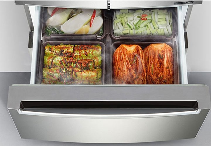 Gaveta aberta de uma geladeira LG, exibindo os recipientes perfeitamente organizados com diferentes tipos de kimchi. A geladeira de aço inoxidável otimiza o armazenamento e a conservação de alimentos fermentados, mantendo-os frescos e bem distribuídos.