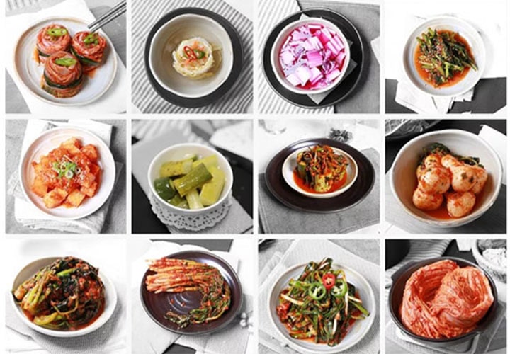 Doze pratos variados de kimchi e vegetais em conserva, mostrando uma variedade colorida de acompanhamentos coreanos.