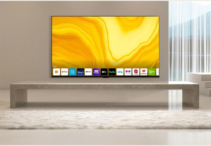 Uma sala de estar minimalista com uma elegante TV LG atrás de um rack de pedra, com uma imagem em amarelo exibida na tela. O design limpo e elegante destaca o estilo e a funcionalidade.
