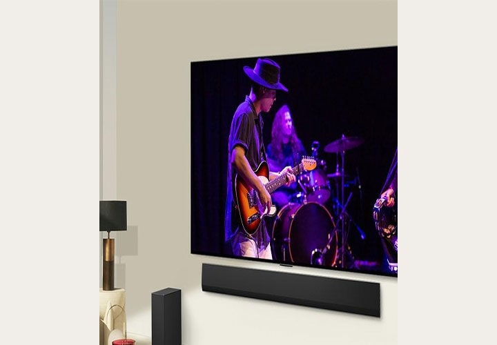 TV OLED com soundbar da LG exibindo uma apresentação de música ao vivo. Perfeita para jogos com qualidade de som e imagem superior.