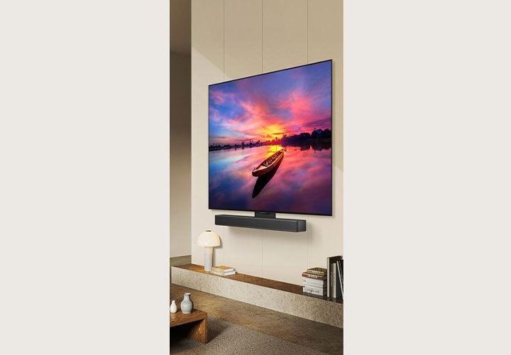 Uma TV LG OLED com soundbar exibe um lindo pôr do sol. Ela oferece excelente qualidade de imagem e som, ideal para jogos e filmes.