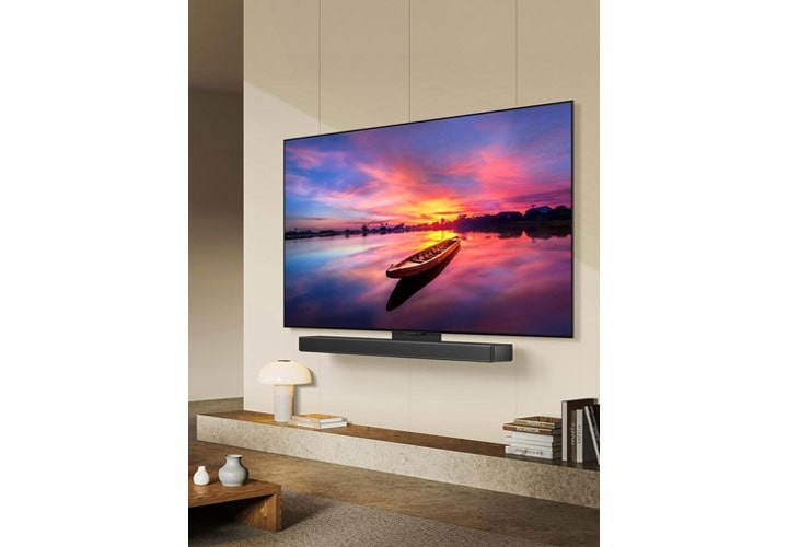 TV LG OLED com aprimoramento de imagem por IA, exibindo um pôr do sol incrível com uma elegante soundbar para criar uma experiência envolvente.