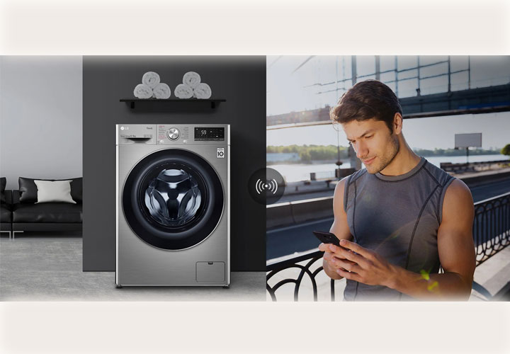Lavadora LG compacta com design moderno em inox, destacando conectividade inteligente com um homem controlando-a pelo smartphone.