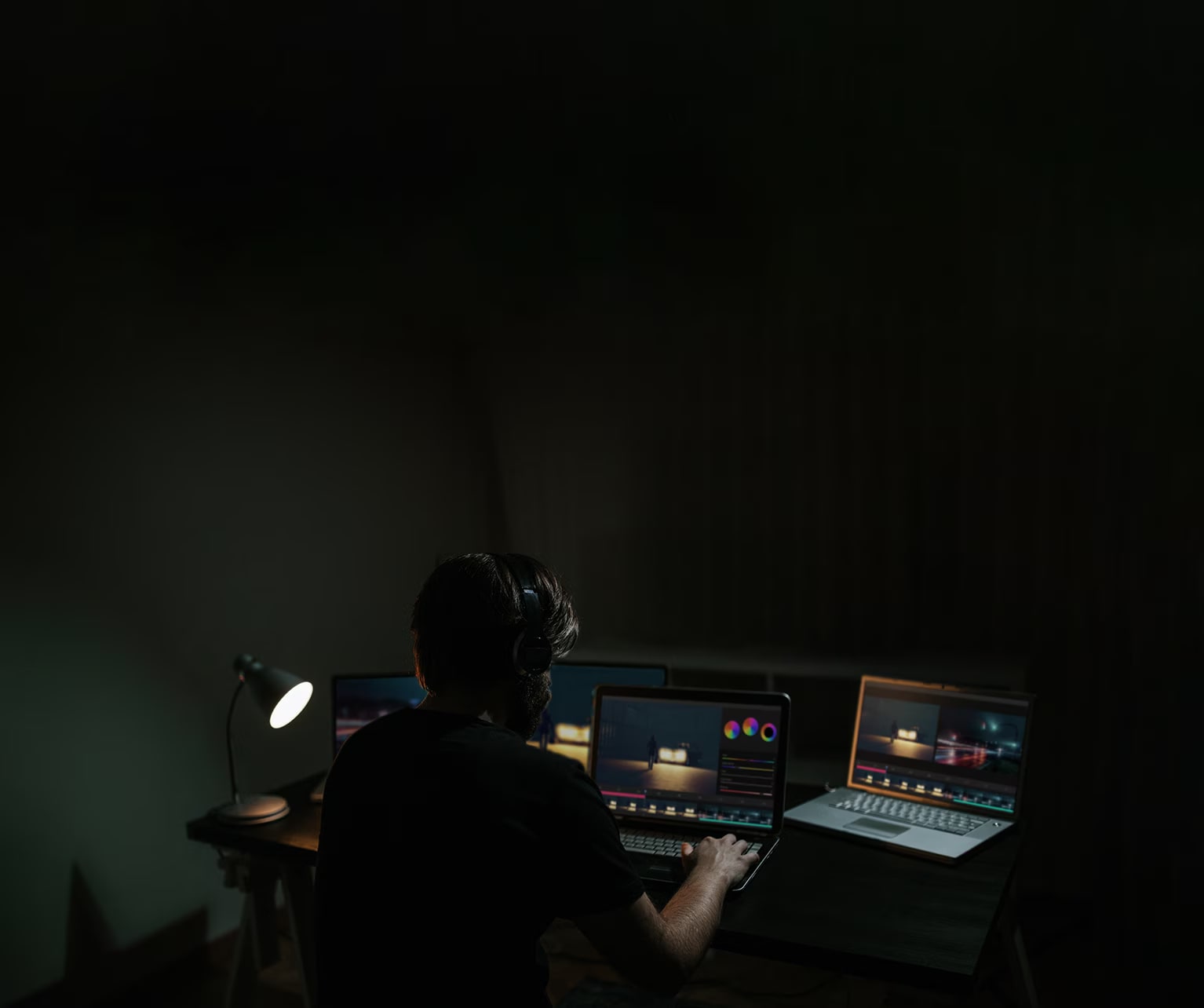 Um homem edita um filme enquanto observa o software em um monitor de computador