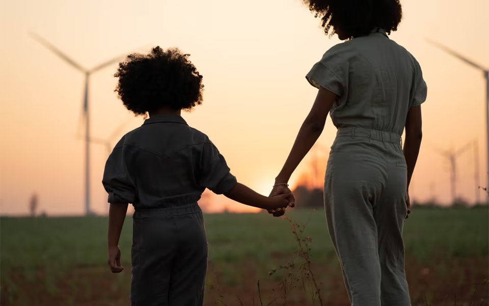 young consumers standing in a field with wind turbines