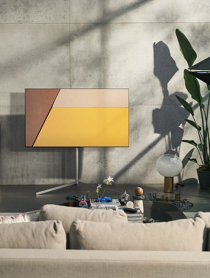 مشهد يظهر به تلفزيون OLED من إل جي في مساحة معيشة رمادية حديثة مقابل نافذة تعرض حوض سباحة. مشهد يظهر به تلفزيون OLED من إل جي في مساحة معيشة محايدة مع ظهور الطوب المكشوف والتفاصيل الخشبية والمساحات الخضراء.