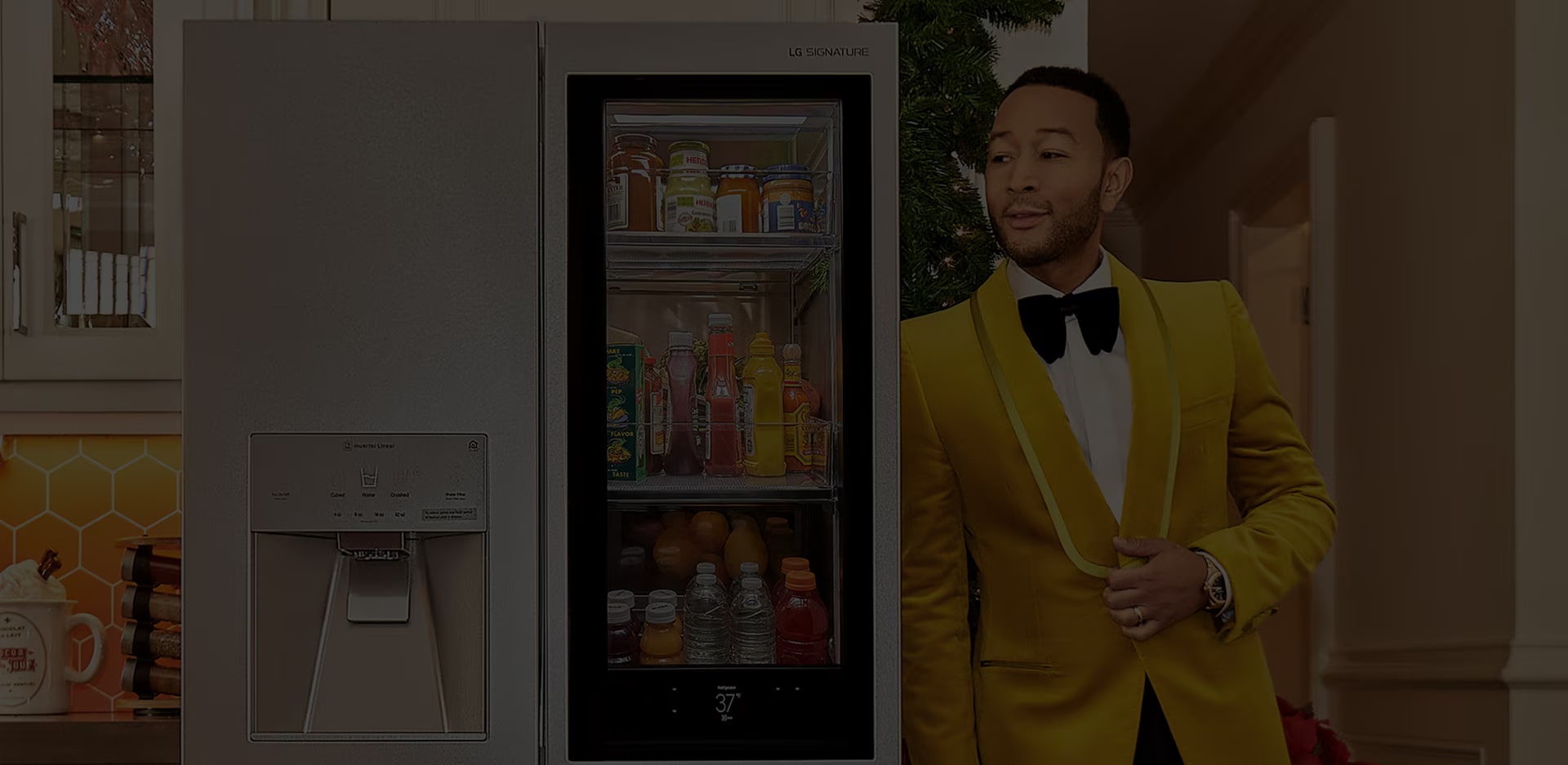 El cantante John Legend apoyado en un refrigerador LG SIGNATURE.