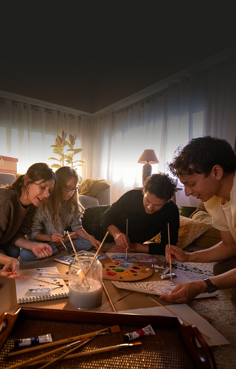 Family members are gathering together in the cozy living room carpet and drawing pictures in a warm house.	