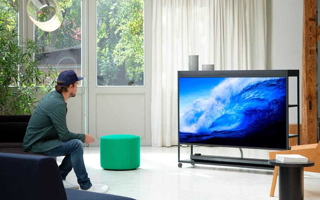 A man who watches LG W7 OLED TV in a living room.