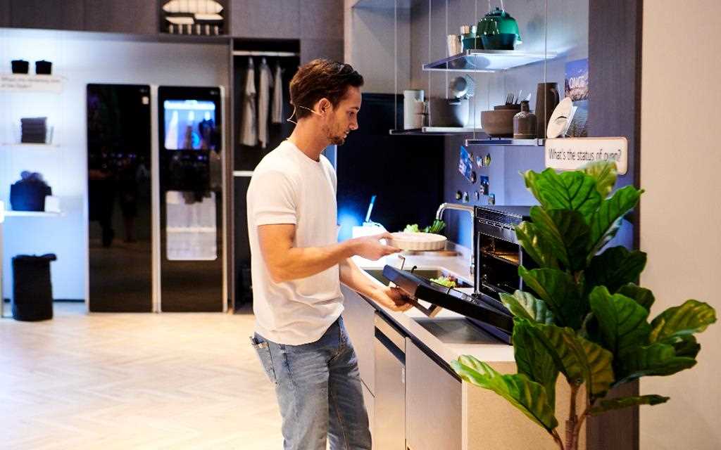 IFA 2018: a demonstrator puts a pizza into the LG NeoChef microwave oven, in the kitchen of the travel zone