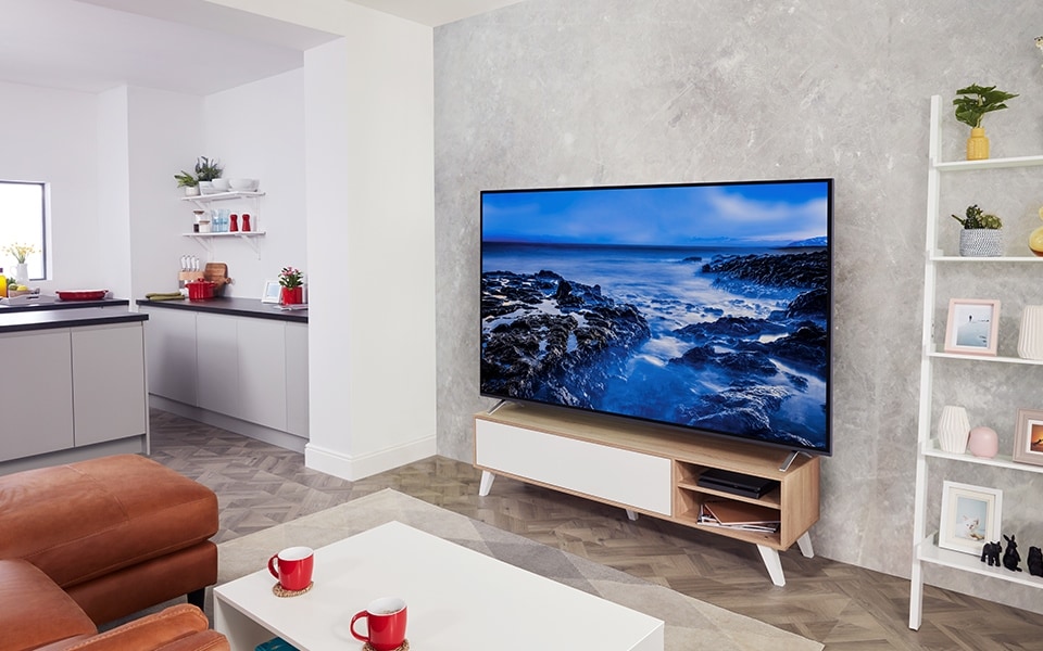 A living room with LG TV displaying a picture a rocky shore