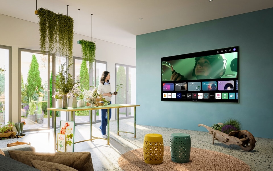 A woman scrolls through WebOS on her LG Smart TV