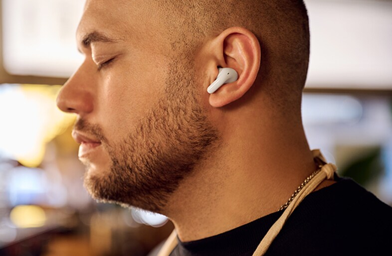 A man is wearing T60 earbuds and listening to music with his eyes closed.