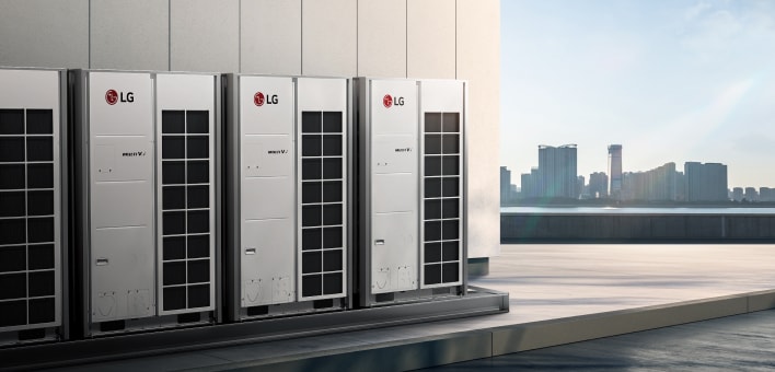 Three LG Multi V outdoor air conditioning units installed side by side on a rooftop, with a river and city skyline in the background.