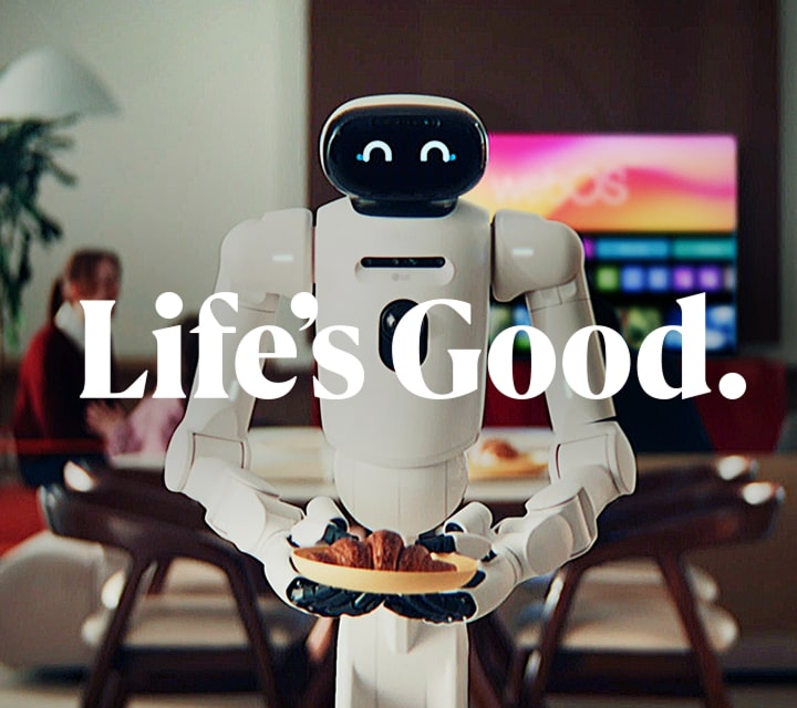 A white LG CLOiD home robot with a smiling digital face stands in a living room holding a plate of croissants. Large white text across the image reads Life's Good. The LG logo is visible on the robot's chest, and a TV in the blurred background displays the text webOS.