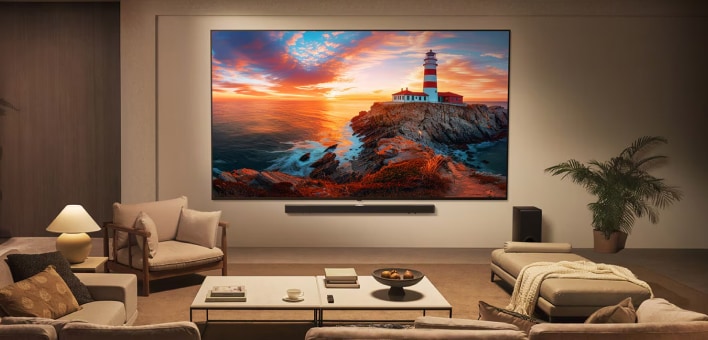 A modern living room with a large wall-mounted TV displaying a colorful sunset and lighthouse landscape, surrounded by elegant furniture.