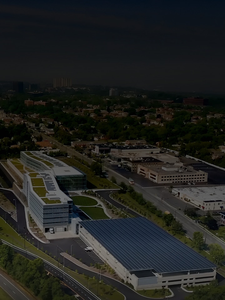 An aerial view of LG Electronics’ eco-conscious headquarters in the United States, showing multiple buildings with rooftop solar panels surrounded by greenery and roads, representing carbon neutrality and the transition to renewable energy