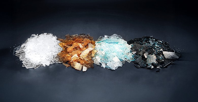 A scene showing different types of raw materials arranged in a row on a dark background, including white, brown, light blue, and black materials, illustrating a diverse range of advanced material compositions