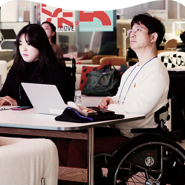 Participants, including a wheelchair user, taking part in LG Electronics’ “Bold Move” accessibility community, sharing their experiences and opinions during a discussion session