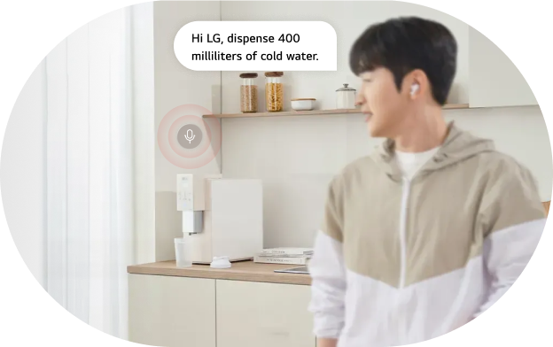 A person using voice command saying “Dispense 150 ml of water” to an LG water purifier in a kitchen
