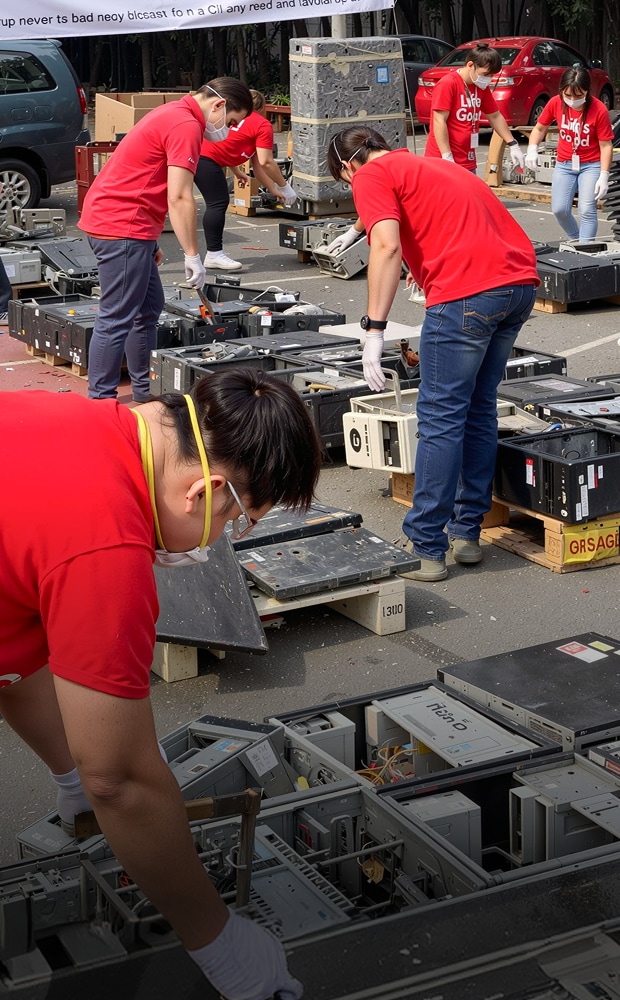 LG employees in red shirts volunteering and organizing electronic equipment during LG Electronics Global Volunteer Day.
