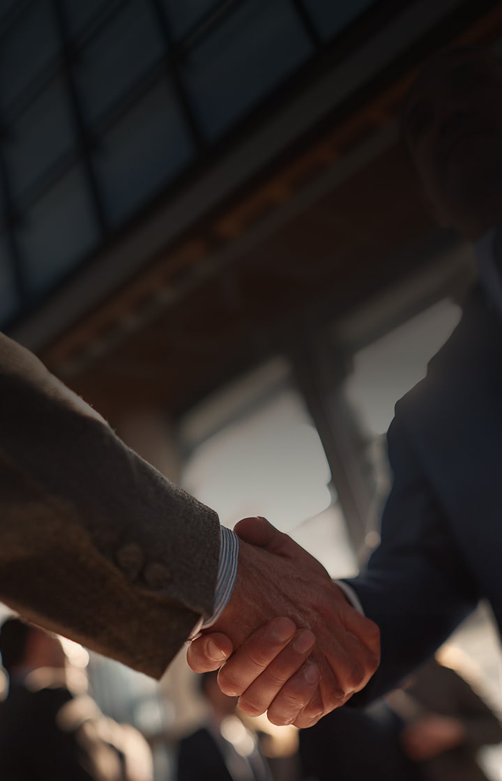 Two people shaking hands, symbolizing business collaboration and trust