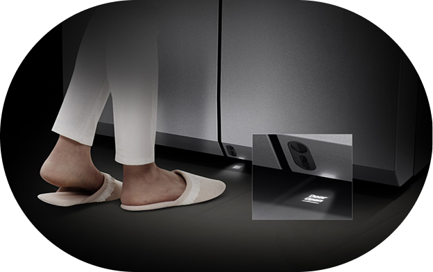 A scene showing the use of the Auto Smart Door feature, with a person standing in front of the lower sensor and opening the refrigerator door without using hands