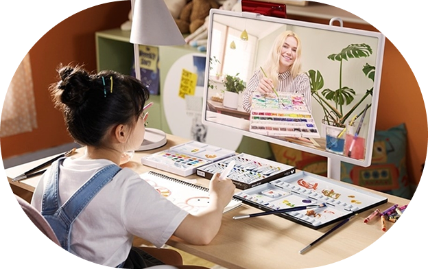 A scene of a child sitting at a desk with art supplies spread out, following a drawing lesson while connected to an instructor on an LG StanbyME screen