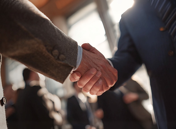 Two people shaking hands, symbolizing business collaboration and trust