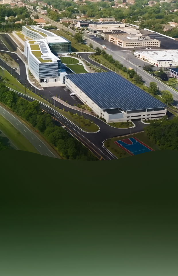 An aerial view of LG Electronics’ eco-conscious headquarters in the United States, showing multiple buildings with rooftop solar panels surrounded by greenery and roads, representing carbon neutrality and the transition to renewable energy.