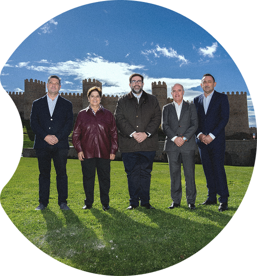 Five people involved in the Smart Green Minerals project standing together on the lawn in front of the city walls of Ávila, Spain.