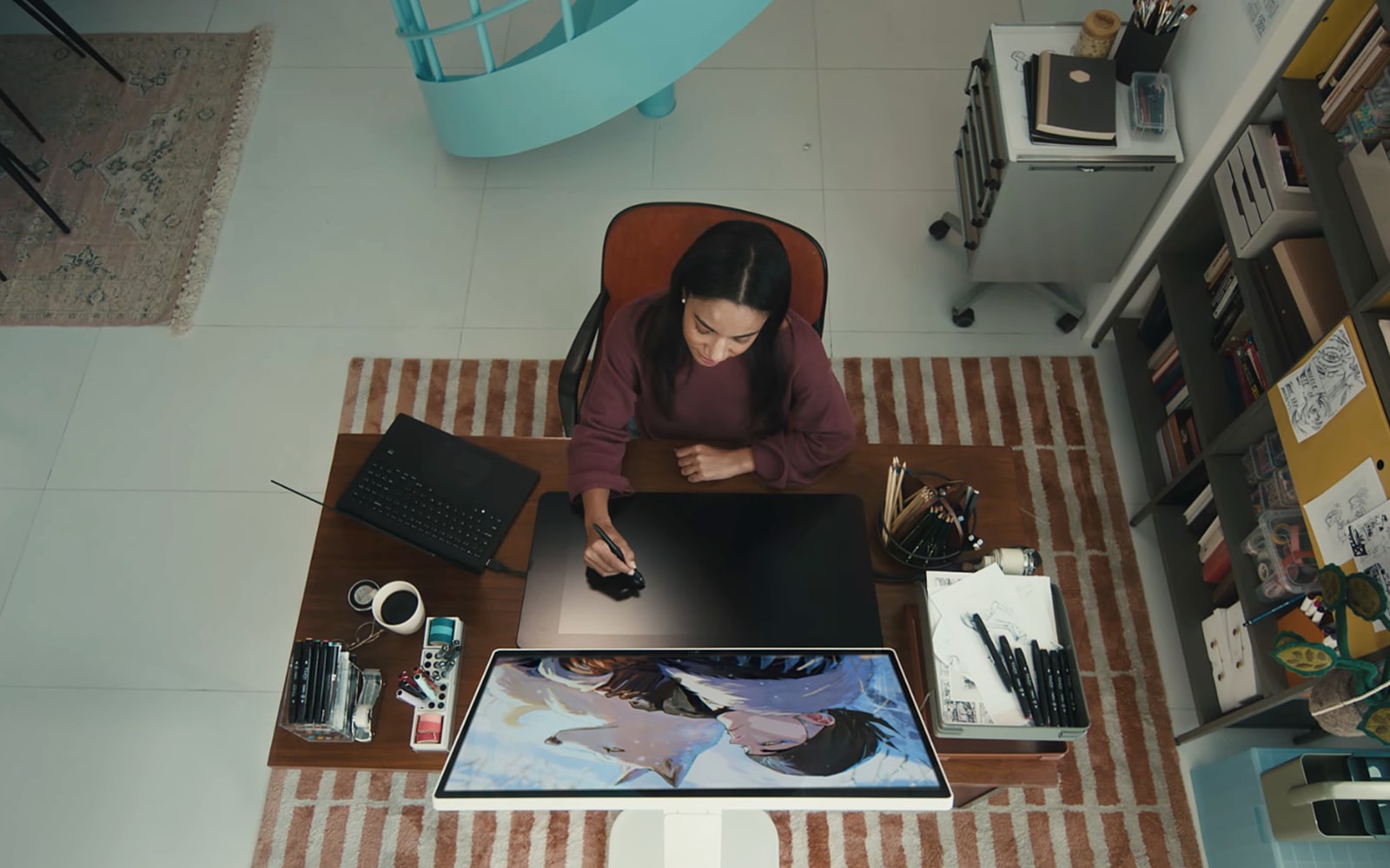 A designer draws on a tablet while looking at an LG 360 monitor.