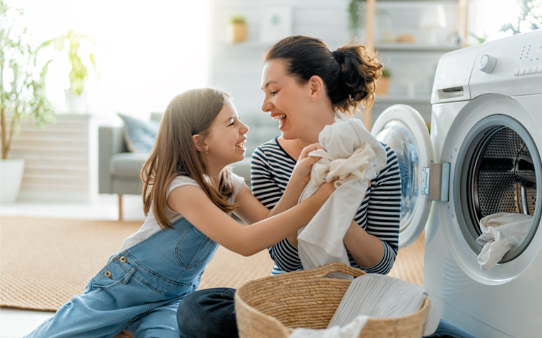 A mother and daughter taking laundry out of an LG dryer.
