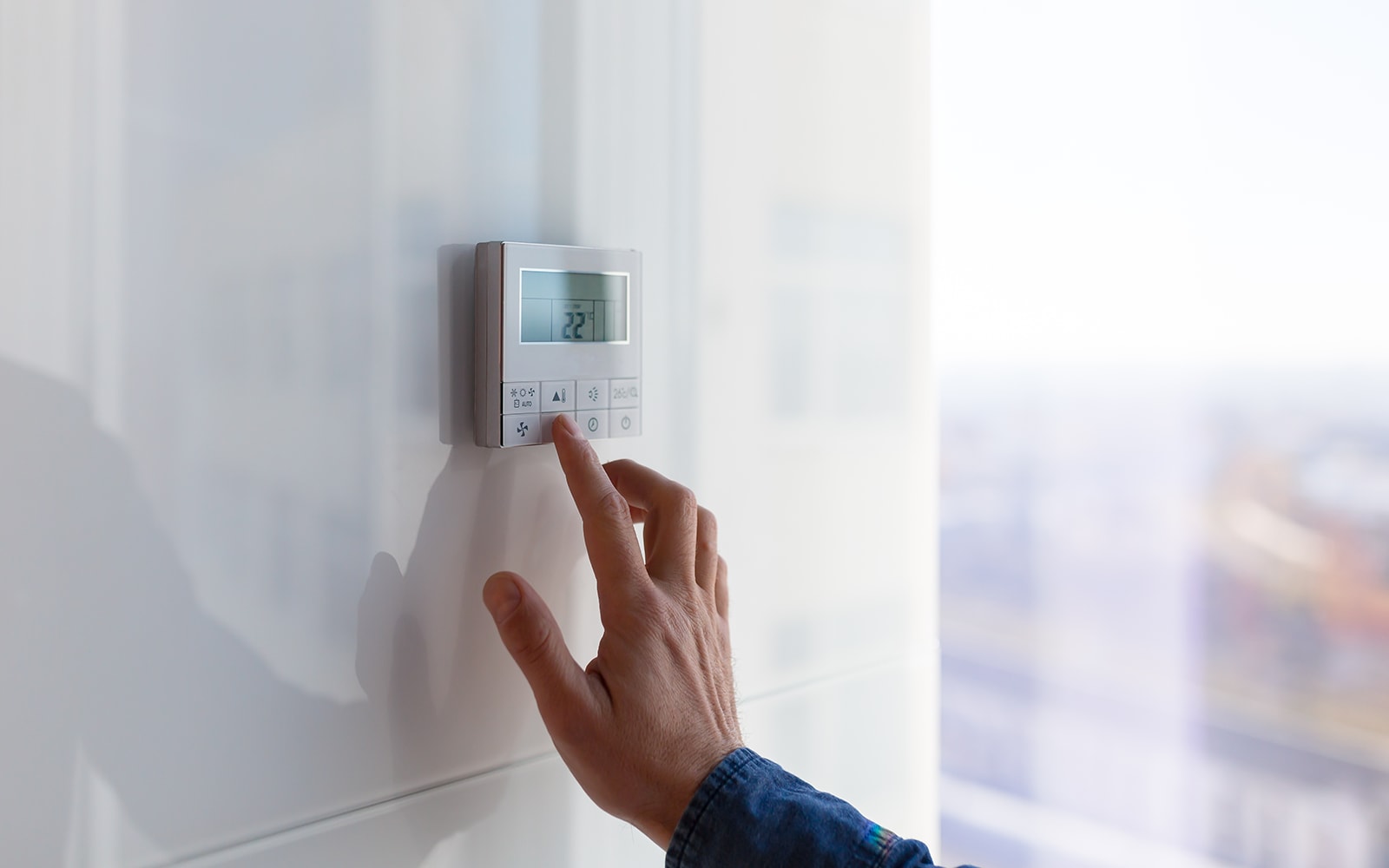 Hand controlling the temperature of the LG HVAC heating and cooling system