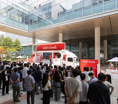 People gather in front of a truck with a sign that says 'Life is good'.