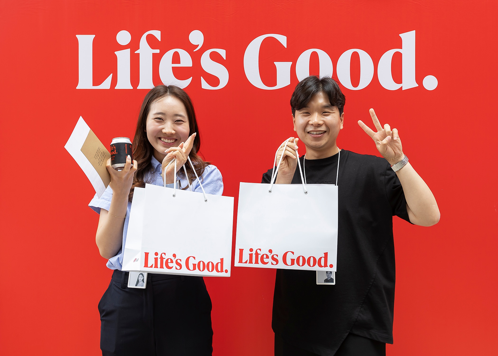 two employee is holding a souvenir paper bag and taking a picture