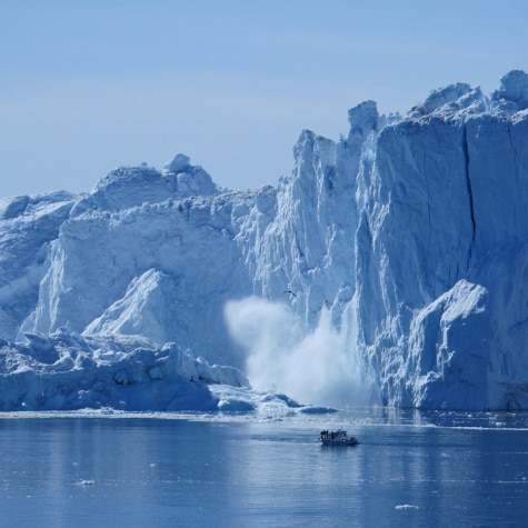 A huge iceberg is collapsing on the sea.